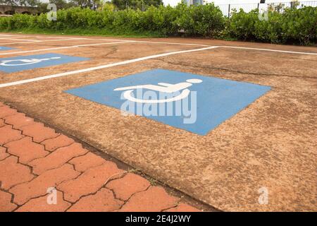 Detail des Behindertenparkplatzes auf Beton. Blau-weißes Schild auf dem Boden gemalt Stockfoto