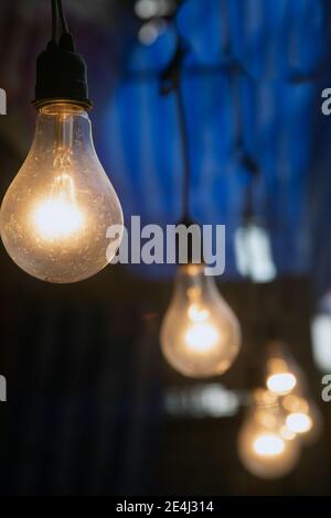 Dekorative Close-up-Lampe, die an der Innendecke leuchtet. Klare Lampen, die ein warmes Licht ausstrahlen. Stockfoto