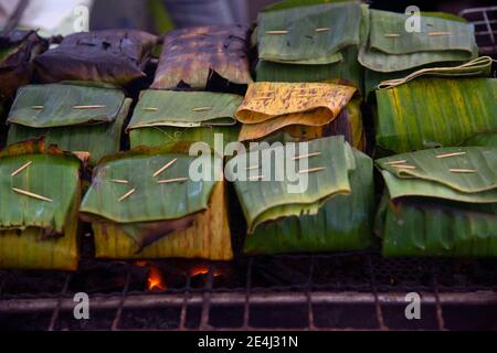 Gedünsteter Fisch mit Currypaste trocknen und darüber mit Kokosmilch und roter Chili in das Bananenblatt streuen. Stockfoto