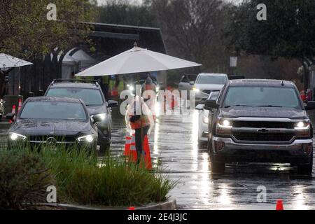 Autofahrer warten in der Schlange im Regen an einer Masse Super Point-of-Distribution Coronavirus COVID-19 Impfstelle am Cal State Northridge, Samstag, Jan. Stockfoto