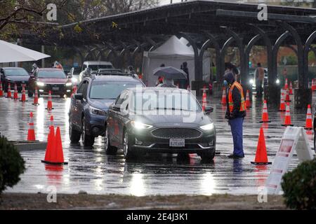 Autofahrer warten in der Schlange im Regen an einer Masse Super Point-of-Distribution Coronavirus COVID-19 Impfstelle am Cal State Northridge, Samstag, Jan. Stockfoto