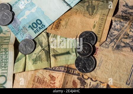 Mehrere brasilianische Münzen und Papierrechnungen, die eine numismatische repräsentative Szene komponieren. Es gibt Reais, Cruzados und Cruzeiros zusammen Stockfoto