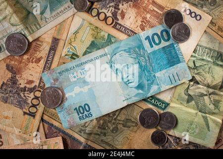 100 reais. Hundert Reais (BRL) werden an der Spitze der ehemaligen Währungen Brasiliens angezeigt. Es gibt Cruzados, Cruzeiros und respektive Münzen Stockfoto