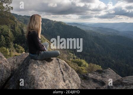Eine Frau blickt auf die bewaldeten Hügel und die Wildnis der Santa Cruz Berge in Kalifornien. Stockfoto