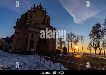 Die Sonne geht über der schneebedeckten Ebene und dem Heiligtum von Varallino di Galliate, Novara, Piemont, Italien Stockfoto