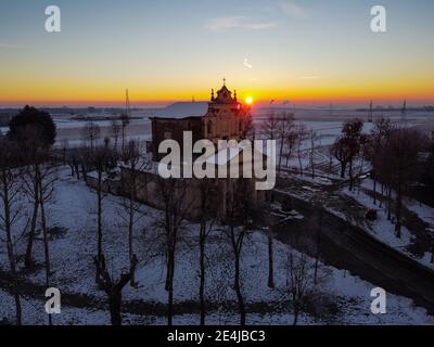 Die Sonne geht über der schneebedeckten Ebene und dem Heiligtum von Varallino di Galliate, Novara, Piemont, Italien Stockfoto