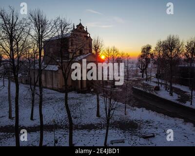 Die Sonne geht über der schneebedeckten Ebene und dem Heiligtum von Varallino di Galliate, Novara, Piemont, Italien Stockfoto