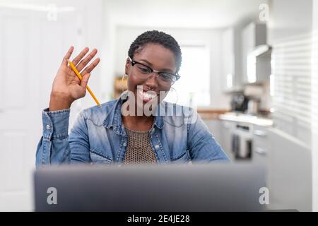 Frau arbeitet mit Videoanruf über Laptop zu Hause Stockfoto