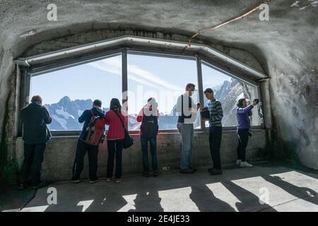 Passagiere mit Blick aus dem Fenster am Bahnhof Eismeer auf der Jungfraubahn im Berner Oberland, Schweiz Stockfoto