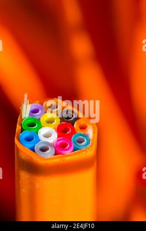 Nahaufnahme des Glasfaserkabels vor orangefarbenem Hintergrund Stockfoto