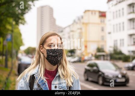 Junge Frau mit Schutzmaske in der Stadt Stockfoto