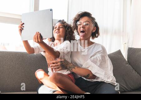Mutter und Tochter machen Gesichter vor dem digitalen Tablet Stockfoto