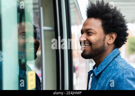 Nahaufnahme eines stylischen Mannes mit mittlerem Erwachsenenalter und eintretenden Afro-Haaren In den Bus Stockfoto