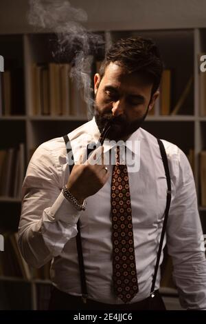 Porträt eines bärtigen Mannes, der Pfeife raucht Stockfoto