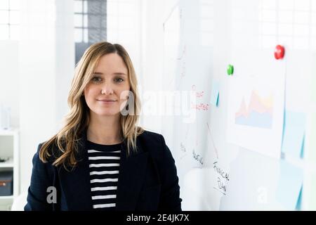 Porträt einer Geschäftsfrau, die im Büro am Whiteboard steht Stockfoto