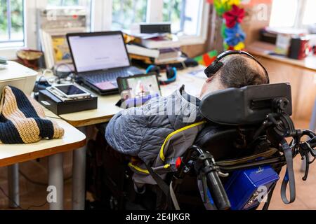 Reifer Mann beim Film auf Laptop im Rehabilitationszentrum Stockfoto