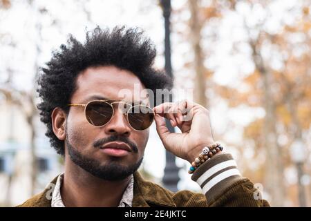 Nahaufnahme eines gutaussehenden Mannes mit Afro-Haaren und Sonnenbrille Stockfoto