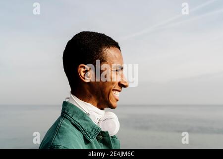 Lächelnder Mann, der am Himmel wegschaut Stockfoto