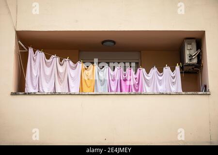 Reihe von bunten Laken auf Wäscheleine auf Balkon Stockfoto