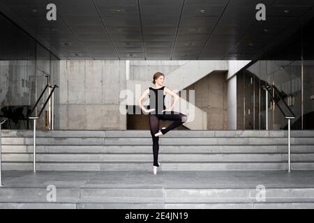 Ballerina in schwarzem Trikot in modernem Betongebäude Stockfoto