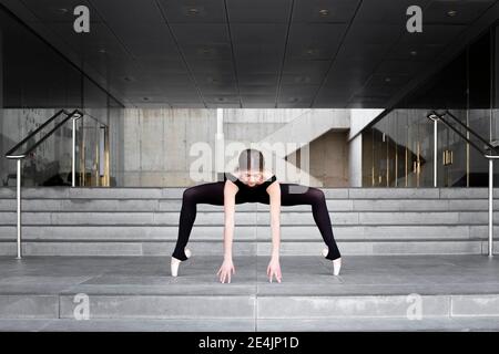 Ballerina in schwarzem Trikot in modernem Betongebäude Stockfoto