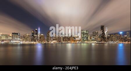 USA, New York, New York City, Midtown Manhattan Skyline beleuchtet in der Nacht über den Fluss gesehen Stockfoto