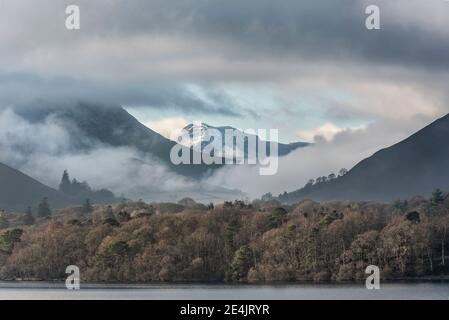 Episches Landschaftsbild mit Blick über Derwentwater im Lake District Catbells schneebedeckter Berg mit dichtem Nebel Rollen durch Tal Stockfoto