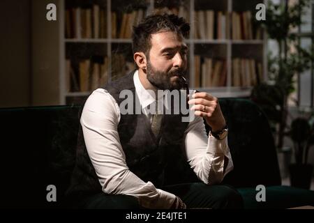 Porträt eines bärtigen Mannes, der Pfeife raucht Stockfoto