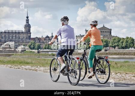 Touristen-Paar mit Elektrofahrrad an der Semperoper, Dresden, Deutschland Stockfoto