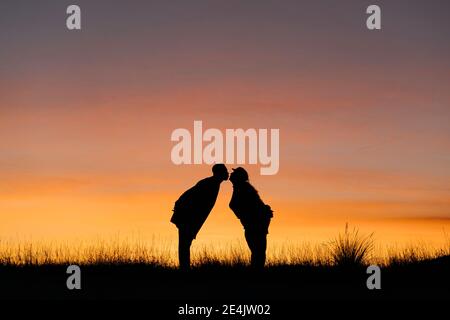 In Silhouette von Freund und Freundin küssen beim Stehen gegen Himmel Stockfoto