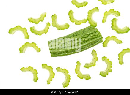 Isolierte Bitterkürbis oder Melone auf weißem Hintergrund, ein Teil des ganzen Bitterkürbis, und einige Scheiben des Bitterkürbis wird herum verteilt. Stockfoto