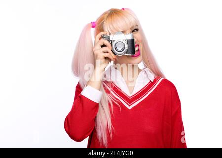 Fröhliche modische Frau fotografieren durch Vintage-Kamera Stockfoto