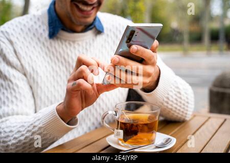 Hände von Mann mit Handy im Café Stockfoto