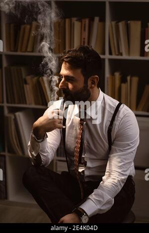 Porträt eines bärtigen Mannes, der Pfeife raucht Stockfoto