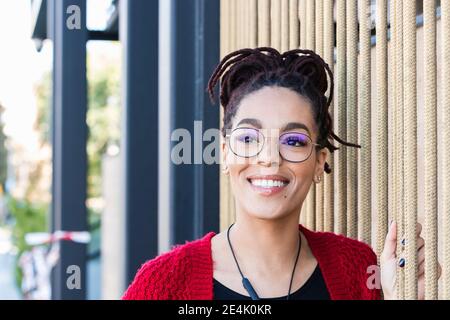 Lächelnd nachdenkliche junge Frau an Seilen Stockfoto