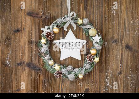 Weihnachtskranz auf brauner Holzwand mit Stern Stockfoto