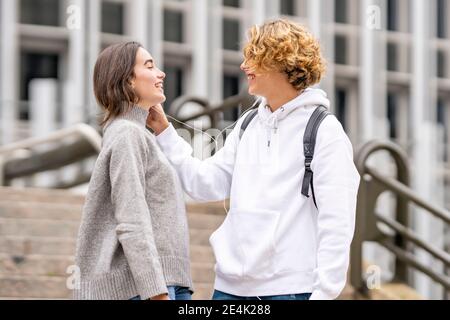 Glückliche Freunde hören Musik über Kopfhörer auf Stufen Stockfoto