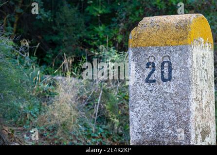 Alte Meilenstein auf der Bailen-Motril-Straße (N-323) ausgesetzt, wie es Führt durch La Cerradura de Pegalajar (Jaen-Spanien) Stockfoto