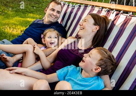Familie lachend während der Entspannung in der Hängematte am Wochenende Stockfoto