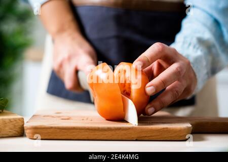 Hände der Frau schneiden Tomate auf Schneidebrett Stockfoto