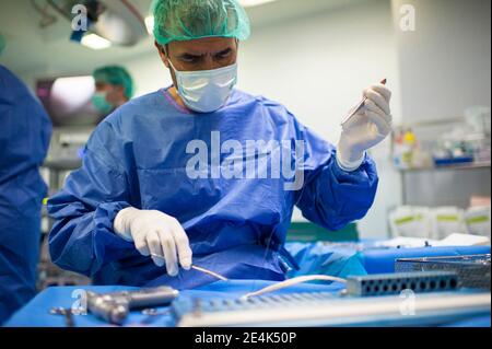 Orthopädischer Chirurg, der eine Pinzette für den Einsatz auf der Intensivstation vorbereitet Stockfoto