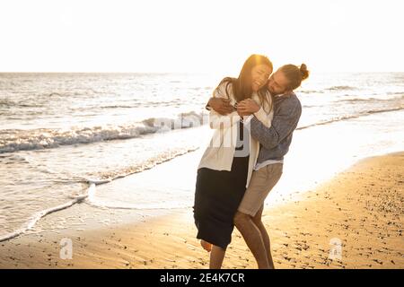 Fröhliches Paar am Strand während sonnigen Tag genießen Stockfoto