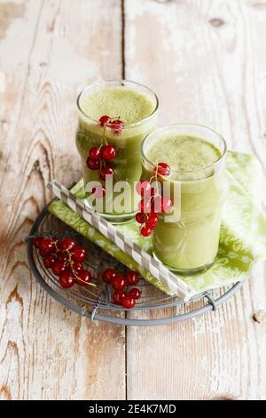 Fresh red currant berries and two glasses of green smoothie Stockfoto