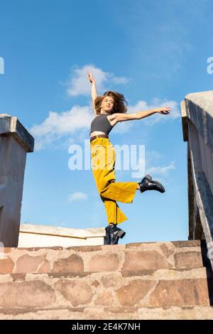 Junge Frau tanzt auf Steintreppen Stockfoto