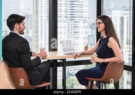 Junge kaukasische Geschäftspartner diskutieren auf Schreibtisch Ecke in modernen Büro Stockfoto