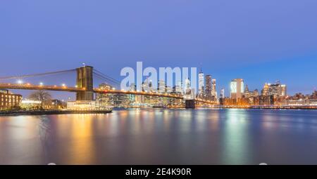 USA, New York, New York City, Brooklyn Bridge und Skyline von Manhattan bei Nacht beleuchtet Stockfoto
