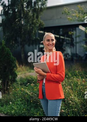 Junge Unternehmerin mit digitalem Tablet im Firmengarten Stockfoto