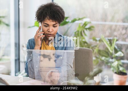 Frau am Telefon sprechen und mit transparenten Display zu Hause Stockfoto