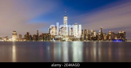 USA, New York, New York City, Lower Manhattan mit One World Trade Center beleuchtet bei Sonnenaufgang über dem Fluss gesehen Stockfoto