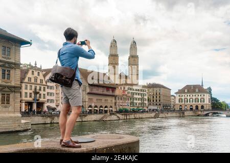 Schweiz, Zürich, man fotografiert Limmat und Altstadtgebäude Stockfoto